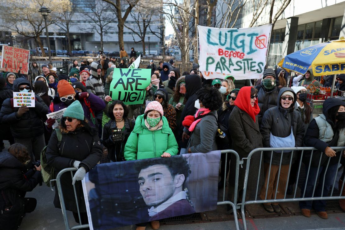 Demonstrators hold placards on the day Luigi Mangione, the suspect in the killing of UnitedHealth Group chief executive Brian Thompson, attends a hearing in Manhattan Criminal Court on New York state murder and terrorism charges in New York City, U.S., February 21, 2025. REUTERS/Jeenah Moon TPX IMAGES OF THE DAY