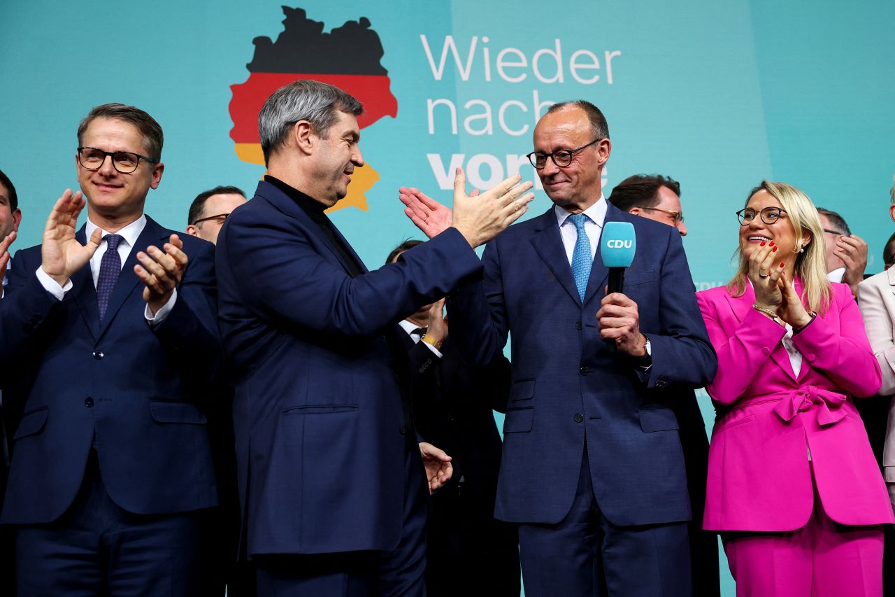 German conservative candidate for chancellor and Christian Democratic Union (CDU) party leader Friedrich Merz celebrates with Bavarian state premier and leader of the Christian Social Union (CSU) Markus Soeder after the exit poll results are announced for the 2025 general election, in Berlin, Germany, February 23, 2025. REUTERS/Kai Pfaffenbach