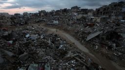 Palestinians walk among the rubble of destroyed buildings in Khan Younis, in the southern Gaza Strip, on February 24, 2025.