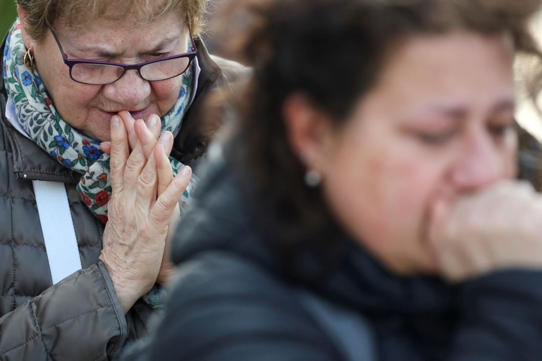 Women pray in front of the statue of late Pope John Paul II outside Gemelli Hospital, where Pope Francis is admitted for treatment.