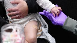 Sherry Andrews, right, holds 13-month-old Jaqi Herrera’s hand after administering the first MMR vaccine dose to Herrera at the City of Lubbock Health Department in Lubbock, Texas, U.S. February 27, 2025.  REUTERS/Annie Rice
