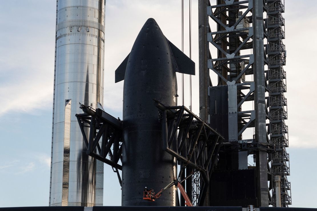 The Super Heavy booster (left) is seen alongside the Starship spacecraft, or upper stage (right), which is secured in the arms of the 