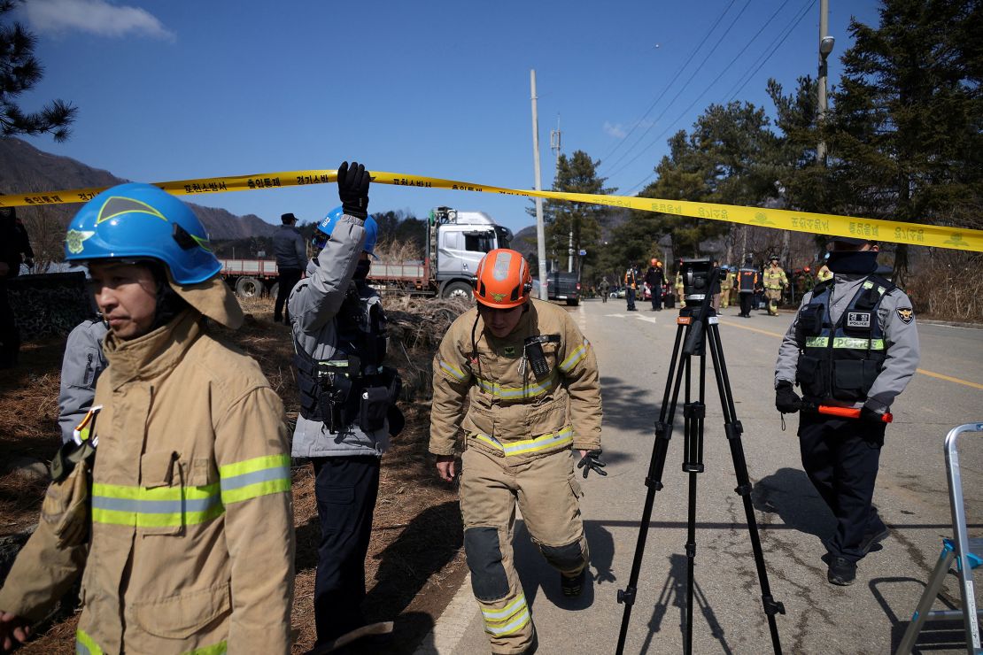 Firefighters and police officers walk at an area cordoned off after MK82 bombs fell outside the shooting range during joint live-fire exercises in Pocheon, South Korea, on March 6, 2025.