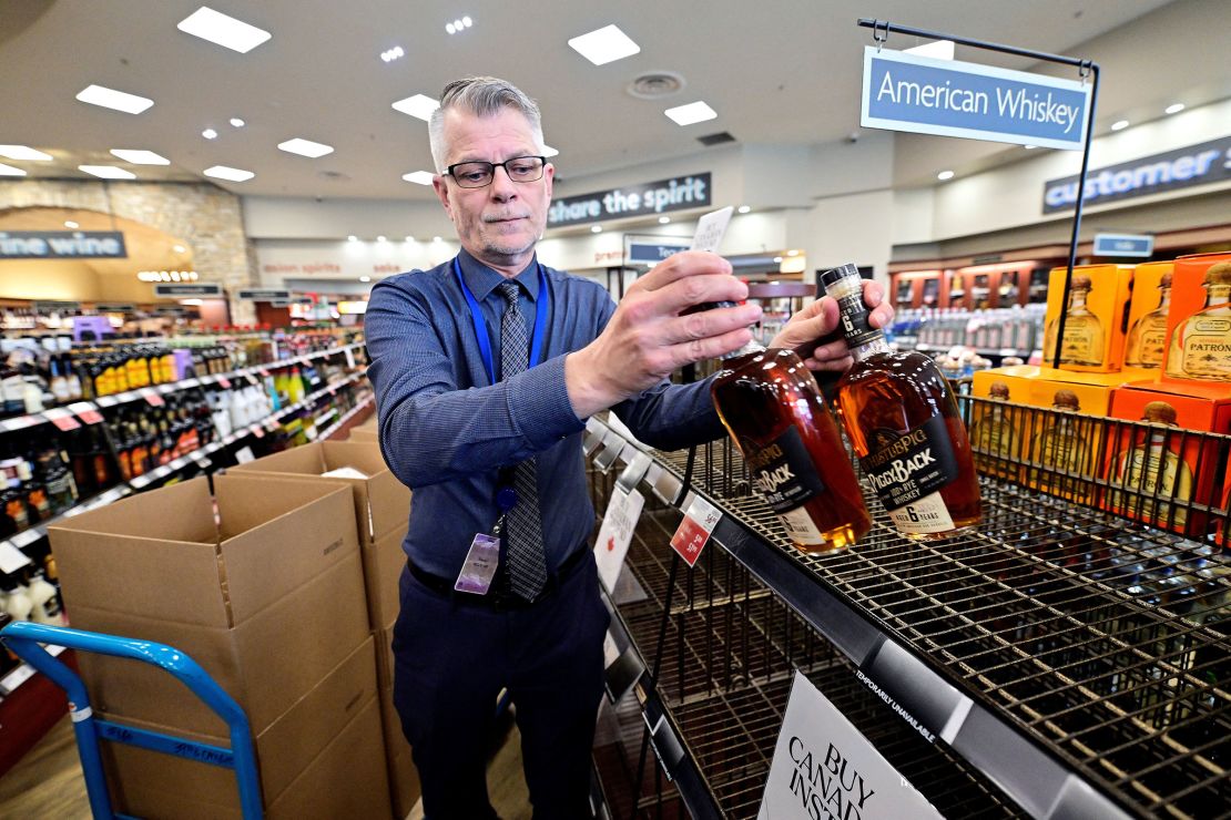 Senior Manager Trevor Hill removes the last bottles of American whiskey from the shelves at the Cambie BC Liquor in Vancouver on March 10.