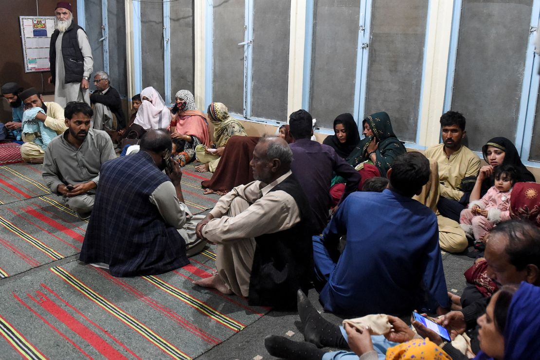 Passengers who were rescued from the train after it was attacked by separatist militants sit at Mach railway station in Balochistan, Pakistan, on Tuesday.