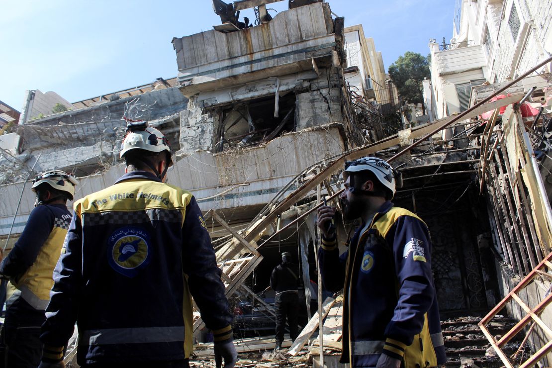 Civil defence members stand at a damaged site after Israel carried out an air strike on the Syrian capital Damascus on Thursday.