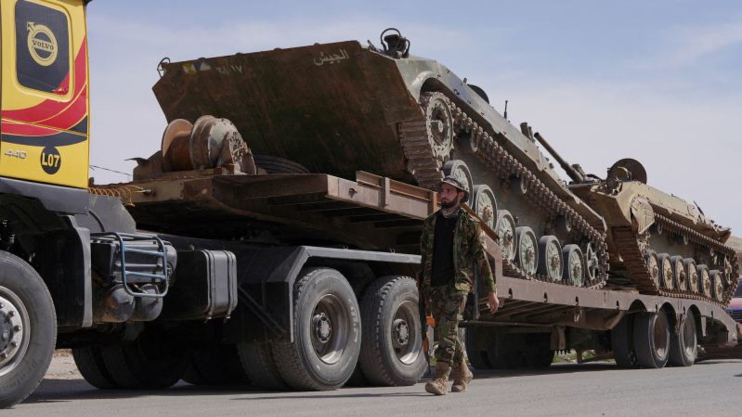 Un miembro de las fuerzas sirias cerca de un vehículo militar que se dirigía a la frontera sirio-libanesa en Qusayr, Siria, el lunes.