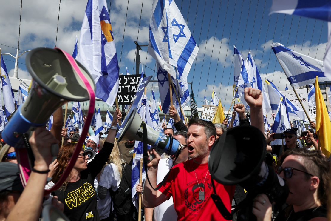 Israelis wave flags and chant through megaphones during Wednesday's protests.