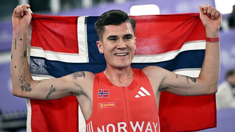 Athletics - World Athletics Indoor Championships - Nanjing Youth Olympic Sports Park, Nanjing, China - March 22, 2025 Norway's Jakob Ingebrigtsen celebrates with his national flag after winning the men's 3000m Final REUTERS/Dylan Martinez