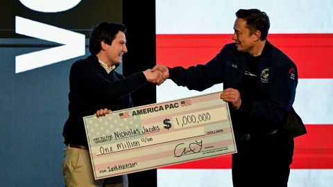 Elon Musk gives a check to an audience member during a rally in support of a conservative state Supreme Court candidate of an April 1 election in Green Bay, Wisconsin, on March 30, 2025.