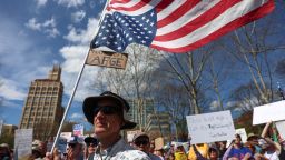 A protestor carries a U.S. flag upside down, during a 'Hands Off!' protest against U.S. President Donald Trump and his adviser Elon Musk, in Asheville, North Carolina U.S., April 5, 2025.