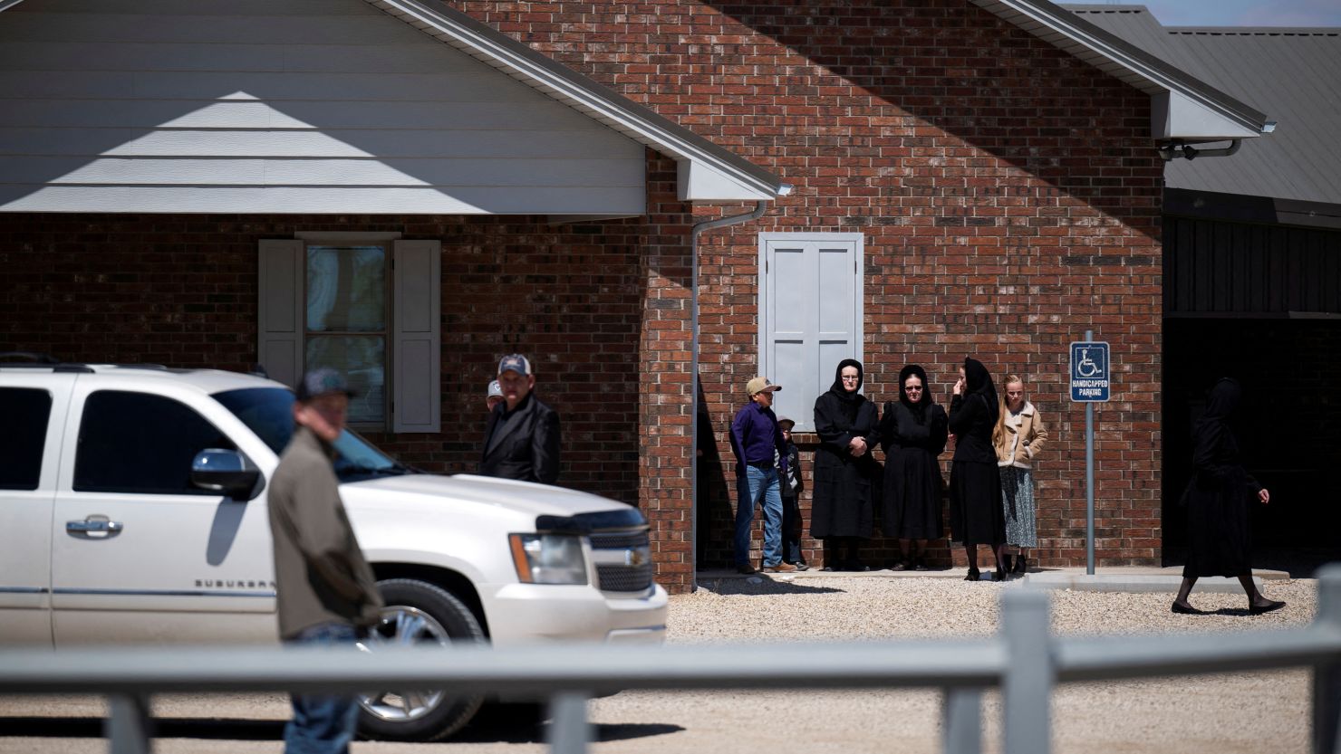 People stand outside a Mennonite church in Seminole, Texas, on April 6 after a funeral for a school-age child who died of measles.
