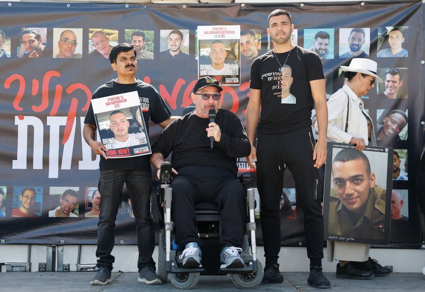 At center, Tal Kupershtein, father of Bar Kupershtein, speaks as family members and supporters of hostages who were kidnapped during the deadly October 7 attack, stand near the kibbutz defence on the day they speak to their captive loved ones over the border between Israel and Gaza, at Kibbutz Nir Oz, in southern Israel, April 20, 2025.