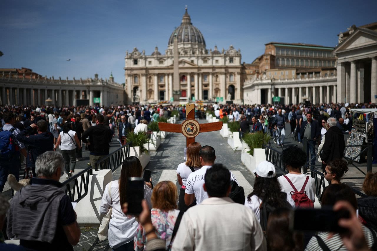Un peregrino lleva una cruz cerca de la plaza de San Pedro en la Ciudad del Vaticano, Italia, después de que el Vaticano anunciara hoy la muerte del papa Francisco.