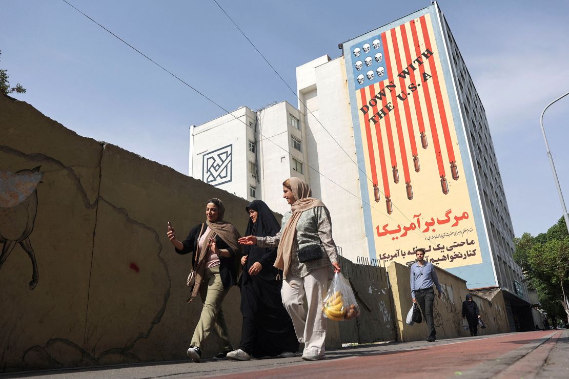 Iranian women walk past an anti-US mural on a street in Tehran, Iran on April 26.