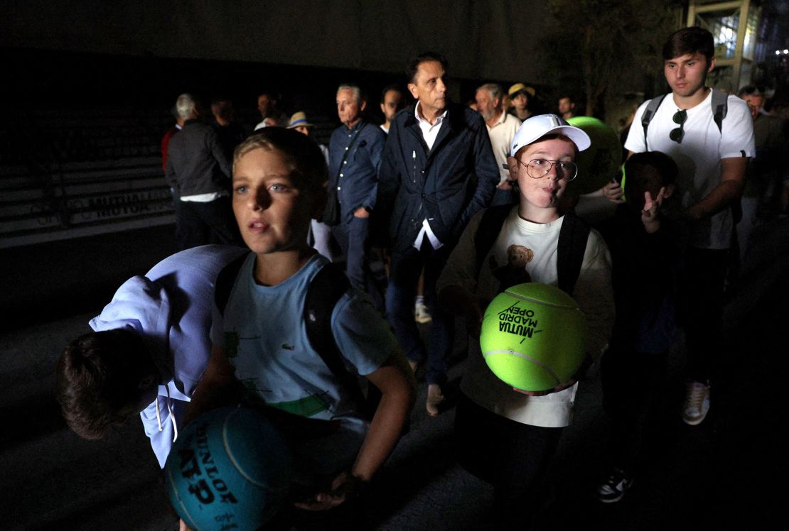 Tennis fans at the Madrid Open filtered out in the dark. The day's matches were suspended.