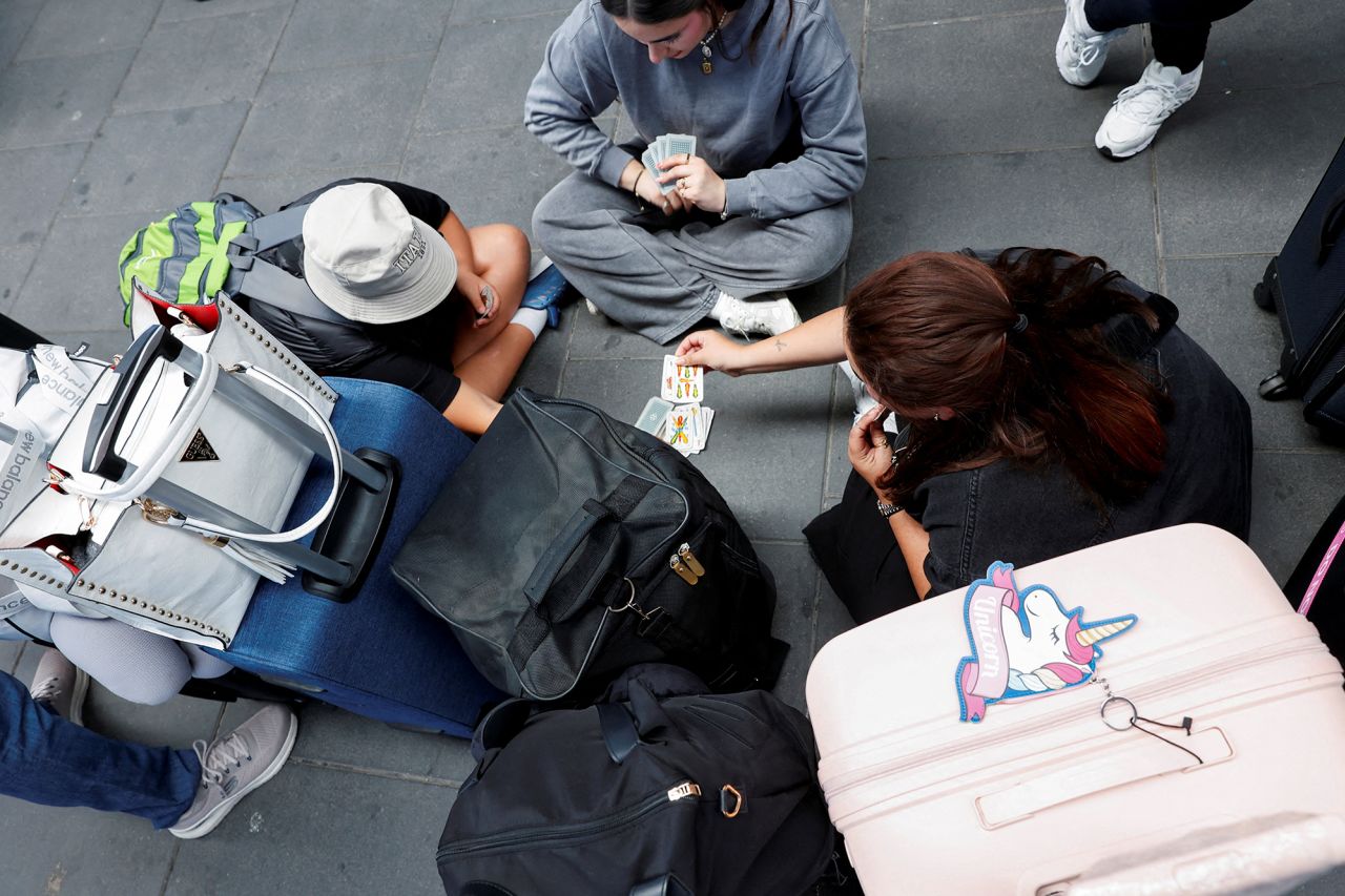 People play cards at Joaquin Sorolla train station in Valencia, today, after passengers were stranded during a power outage which hit large parts of Spain.