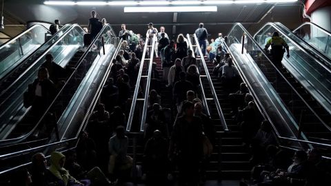 La gente descansa en las escaleras de la estación de tren de Atocha en Madrid el lunes.