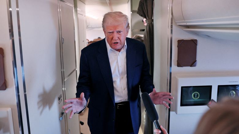 President Donald Trump speaks to members of the media aboard Air Force One.