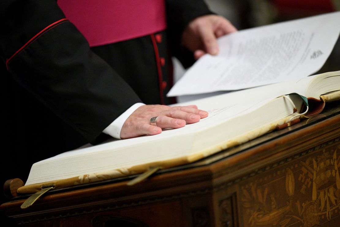 Officials, members of the clergy and conclave staff take an oath of secrecy in the Pauline Chapel, at the Vatican, on Monday.