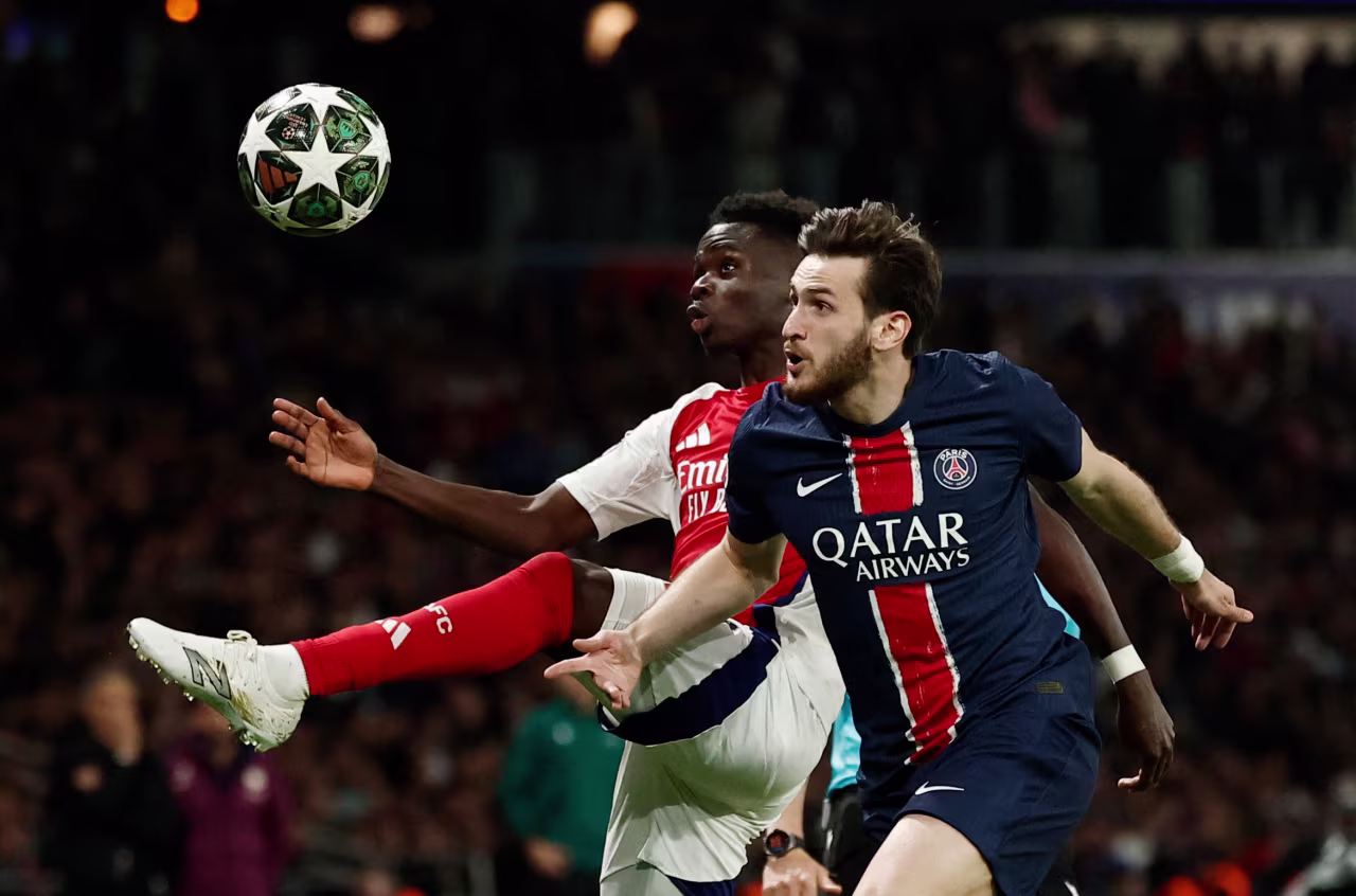 Arsenal's Bukayo Saka in action with Paris Saint-Germain's Khvicha Kvaratskhelia.