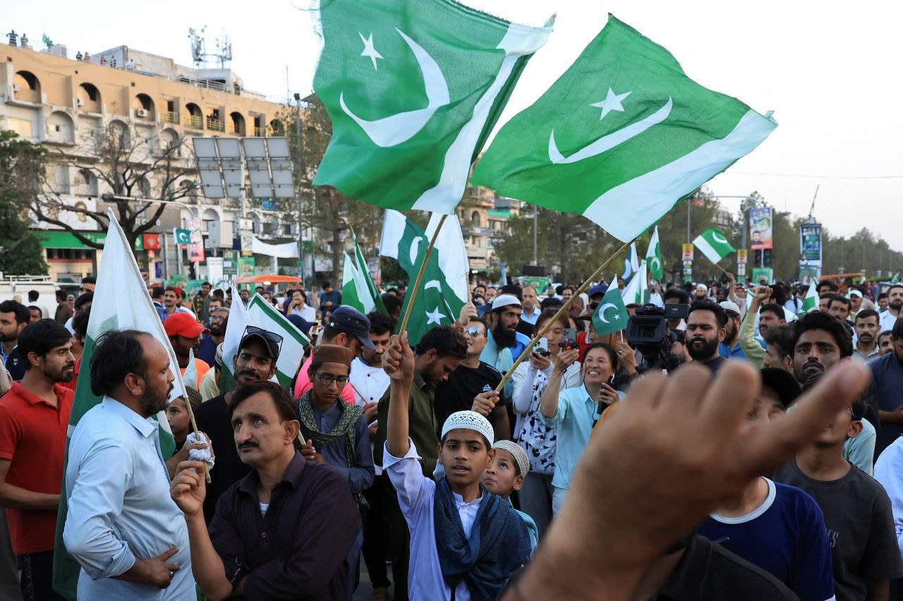 La gente ondea banderas paquistaníes en celebración después del anuncio del alto el fuego con India, en Islamabad, Pakistán, el sábado.