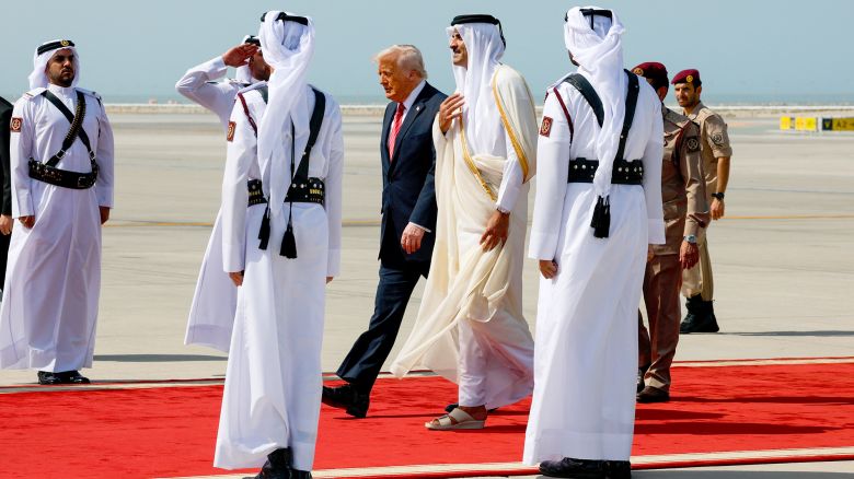 U.S. President Donald Trump walks with Qatar's Emir Tamim bin Hamad Al Thani upon his arrival at Hamad International Airport, in Doha, Qatar, May 14, 2025. REUTERS/Brian Snyder
