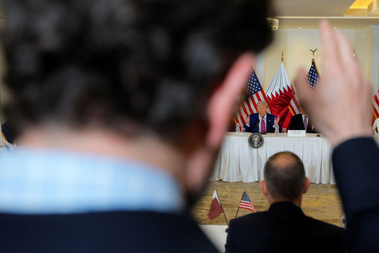 A reporter raises their hands to ask a question during a roundtable discussion with President Donald Trump in Doha, Qatar, on Thursday.