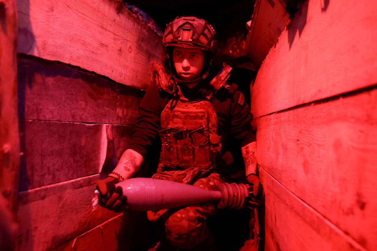 A Ukrainian service member carries a mortar shell before firing it at Russian troops, in Ukraine's Donetsk region, on Friday.