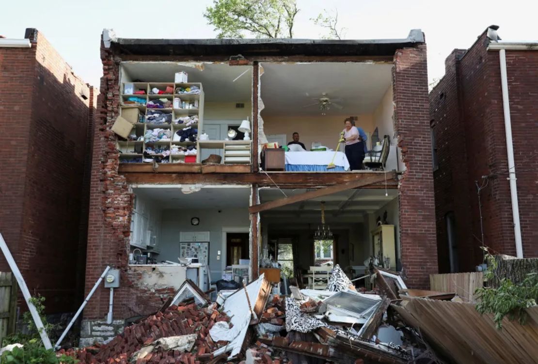 Residentes inspeccionan su casa después de que un tornado arrancara la pared trasera de una casa de dos plantas en St. Louis, Missouri.