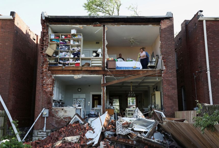 Residents inspect their home after a tornado tore off the back wall of a two-story house in St. Louis, Missouri.
