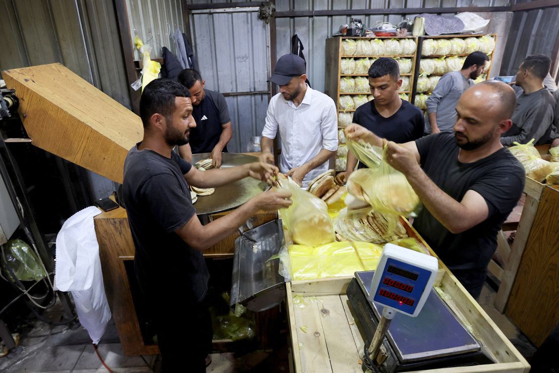 Palestinian workers pack bread in a bakery in Deir Al-Balah in the central Gaza Strip, May 22, 2025.