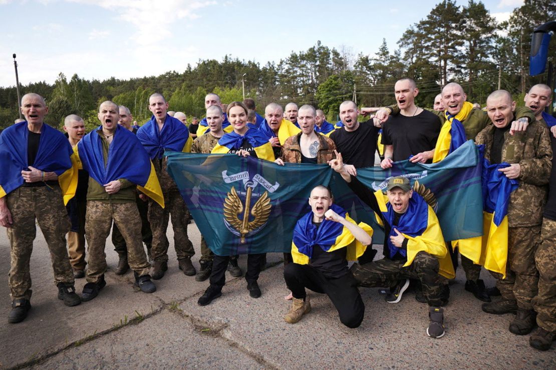 Ukrainian prisoners wave flags in celebration after the swap on Friday.