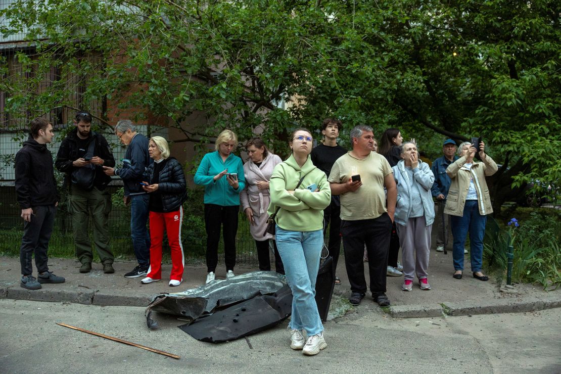 Residents look at a damaged apartment building.
