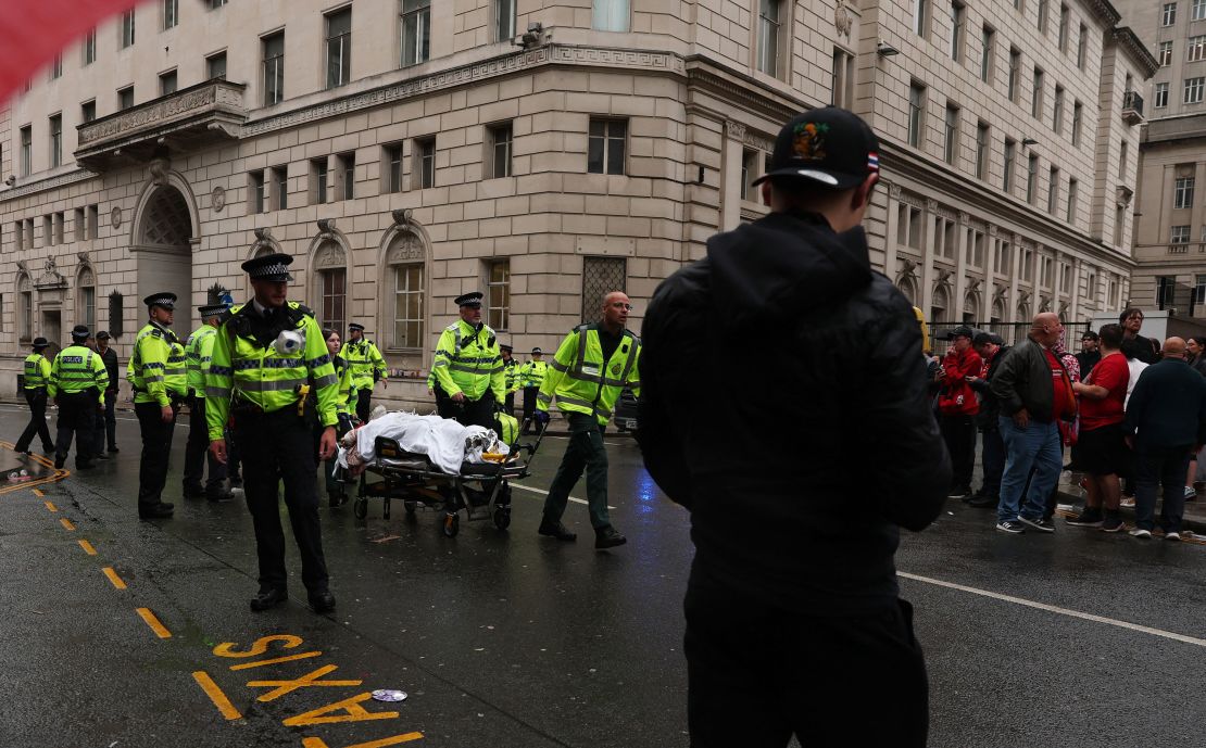 A person is taken away on a stretcher following a car collision in Liverpool on Monday.