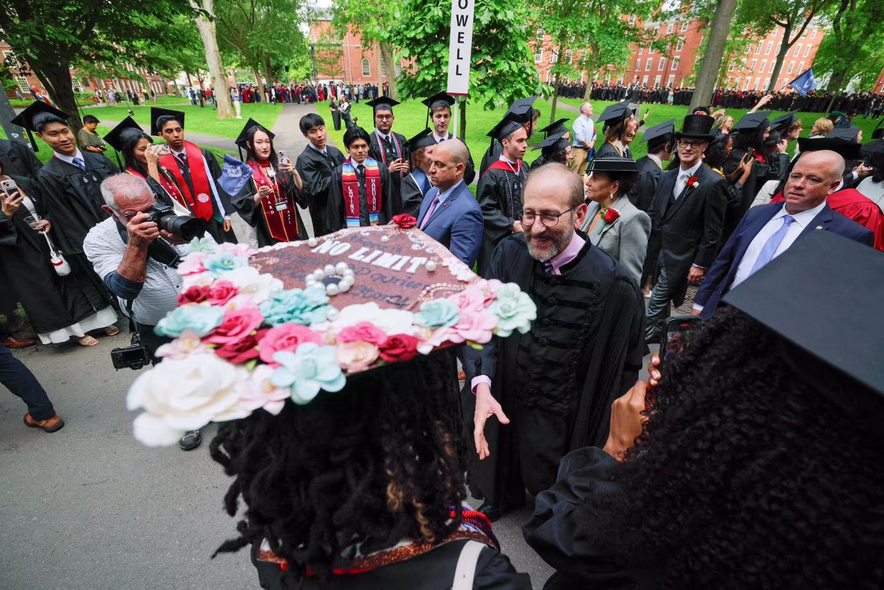 Harvard University President Alan Garber greets students as they arrive to the commencement ceremony.