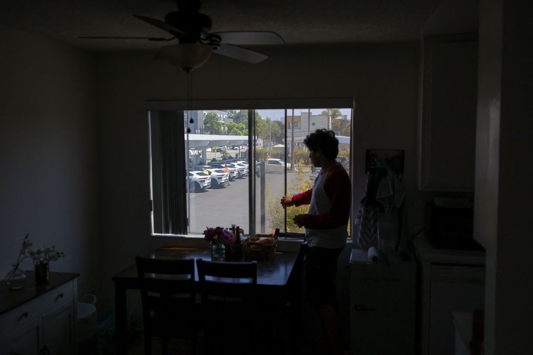 A Santa Monica resident looks out their window at a Waymo charging lot. The beeping noise that the driverless vehicles make to indicate that they are reversing has become a disturbance for residents who live around the lots.