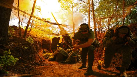 Ukrainian soldiers fire a Howitzer towards Russian troops on a front line in Ukraine's Kharkiv region on Monday.