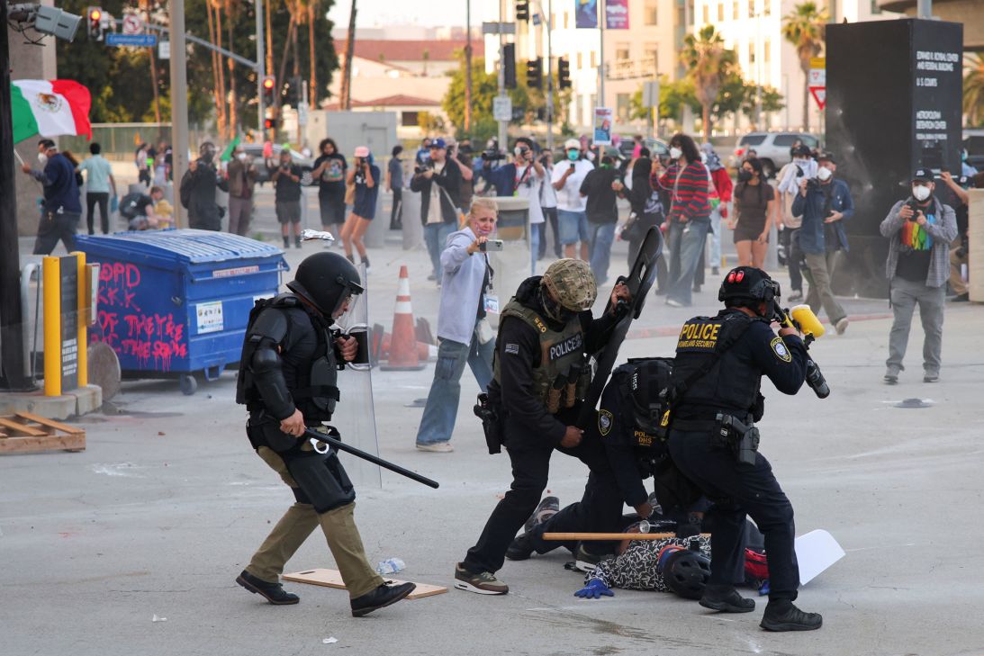 Police detains a protester blocking the garage entrance of the Los Angeles Federal Building, on Friday.