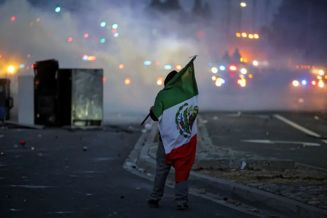 Un manifestante ondea una bandera mexicana durante un enfrentamiento entre la policía y manifestantes en Compton, California, el sábado.