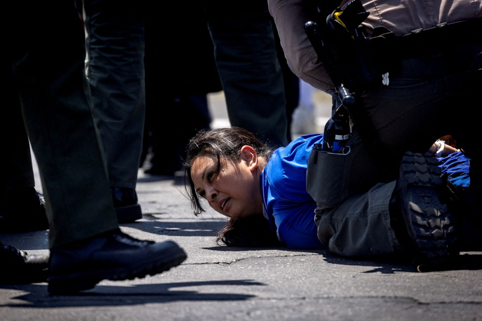 Los Angeles County Sheriff's deputies detain a woman during a standoff by protesters and law enforcement, following multiple detentions by Immigration and Customs Enforcement (ICE).