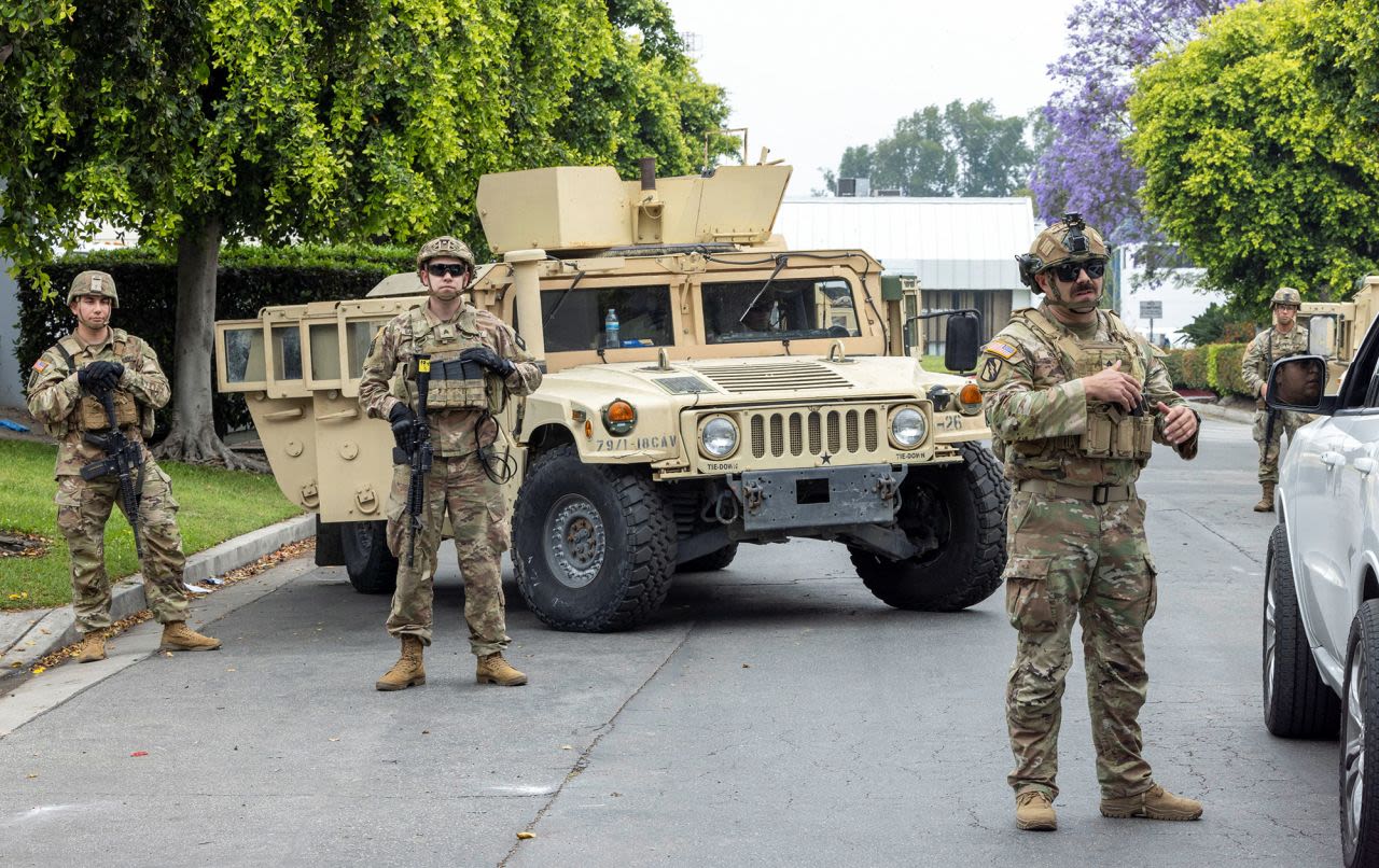  de la Guardia Nacional de California montan guardia en el estacionamiento del Centro Empresarial Paramount, en la ciudad de Paramount, condado de Los Ángeles, el domingo.