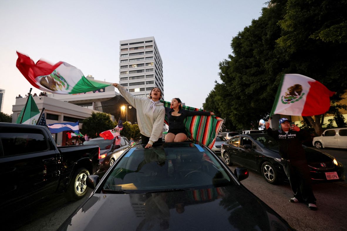 Demonstrators wave Mexican flags in downtown Los Angeles while protesting federal immigration sweeps on Monday.