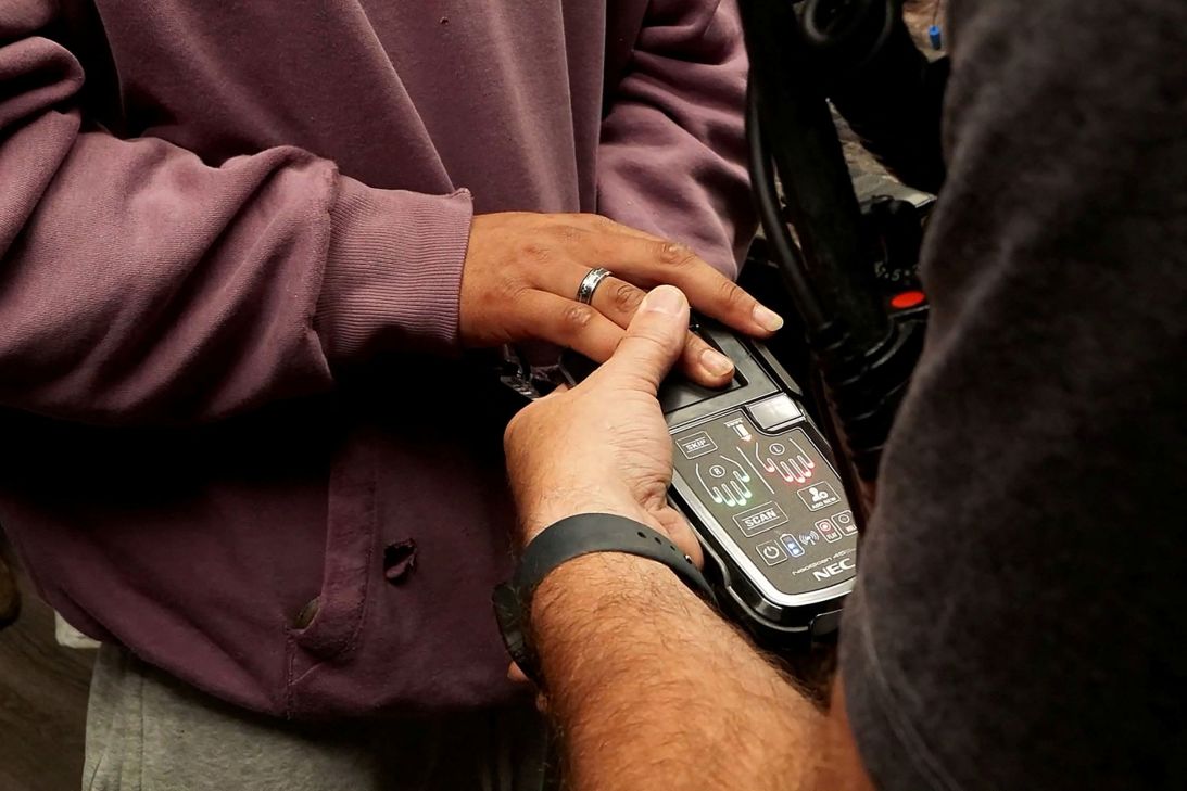 A worker has their fingerprints checked electronically as seen on a video released by the government.