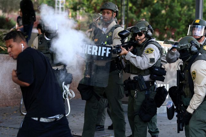 A law enforcement officer shoots a non-lethal weapon at a protester on Wednesday.