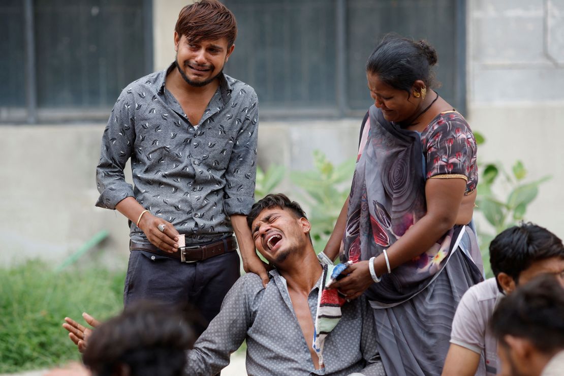 Kalpeshbhqi Patni, 28, mourns as he waits outside the postmortem room at a hospital, for his brother's body in Ahmedabad, India, June 13, 2025.