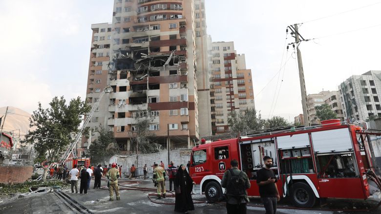 Firefighters work at the scene of a damaged building in the aftermath of Israeli strikes in Tehran, Iran, on Friday.