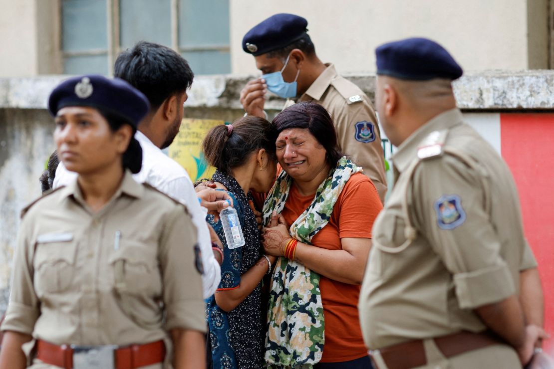 Relatives of victims mourn as they wait outside the postmortem room at a hospital, in Ahmedabad, India, June 13, 2025.
