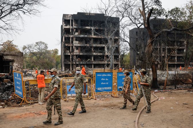 Security personnel walk near damaged buildings at the crash site on Friday.