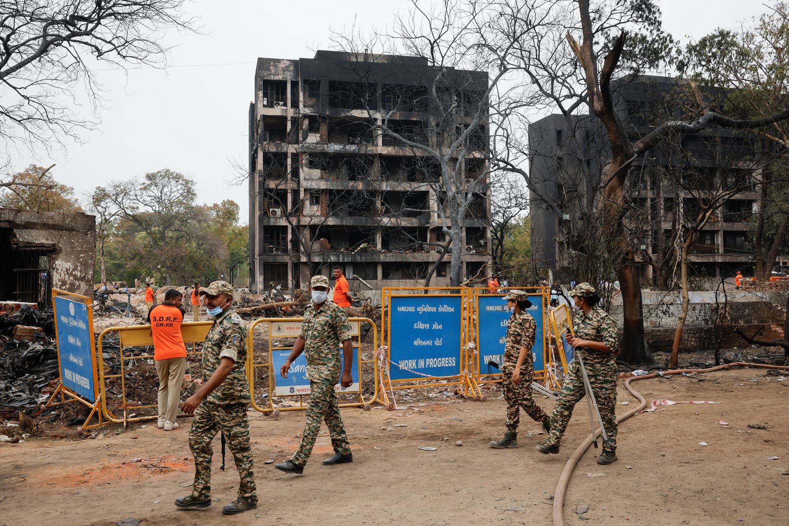 Security personnel walk near damaged buildings at the crash site on Friday.